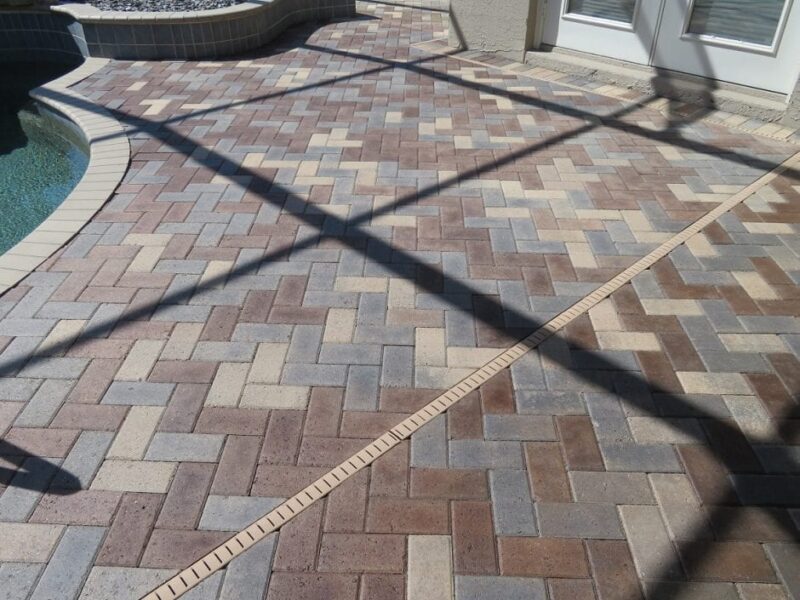 Fully sealed and finished pool deck pavers, gleaming under the sunlight, showing off their revived colors