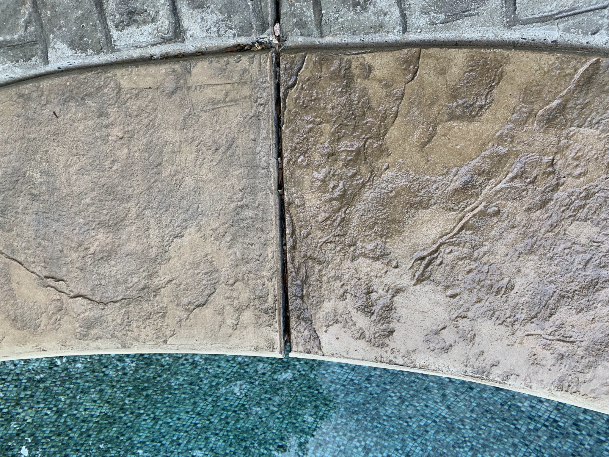 In-progress photo showing half of the pool coping with fresh Khaki stain and the other half in its original state.
