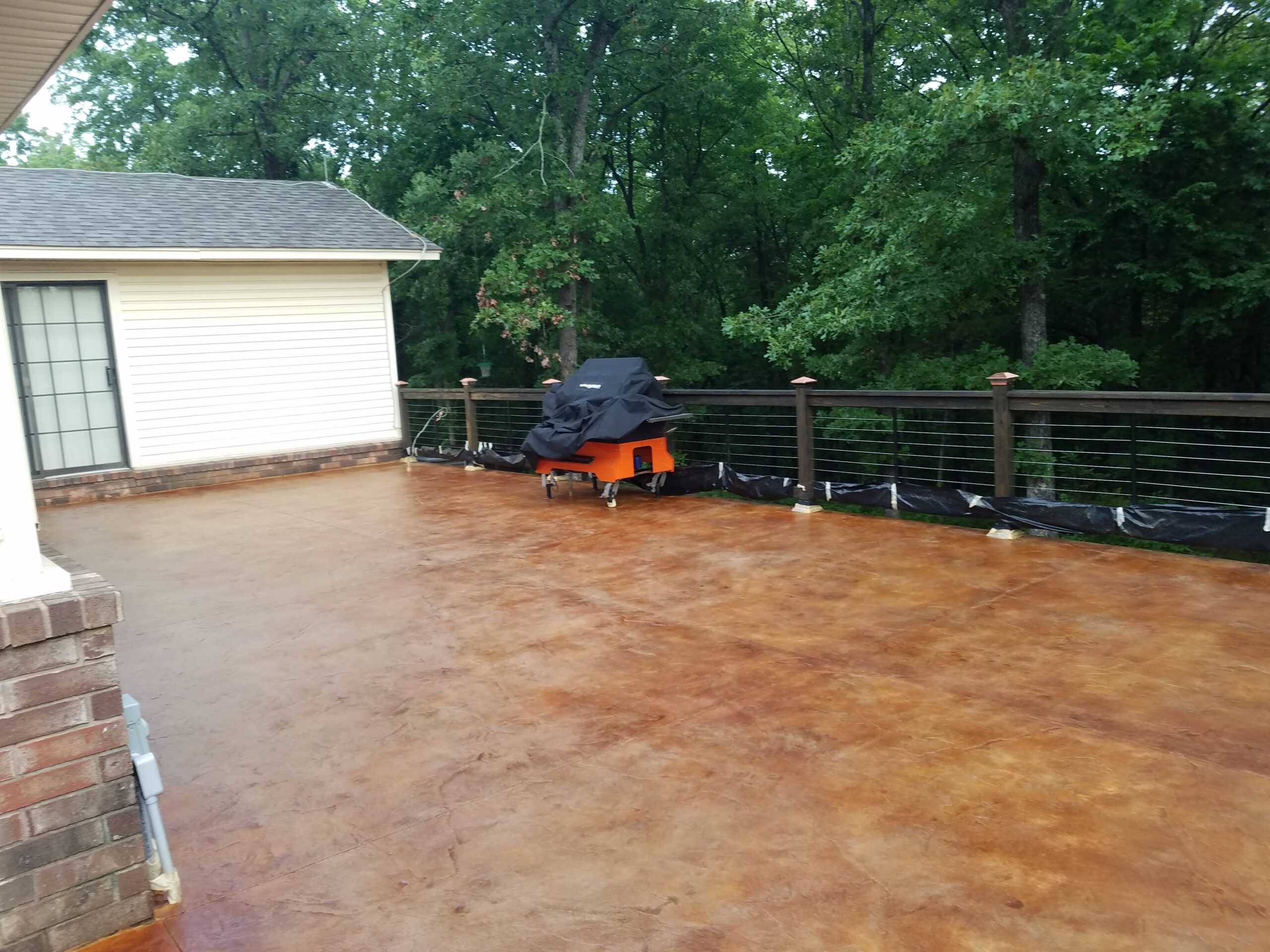 An image of a concrete porch, highlighting the BBQ area and the depth of the stain color