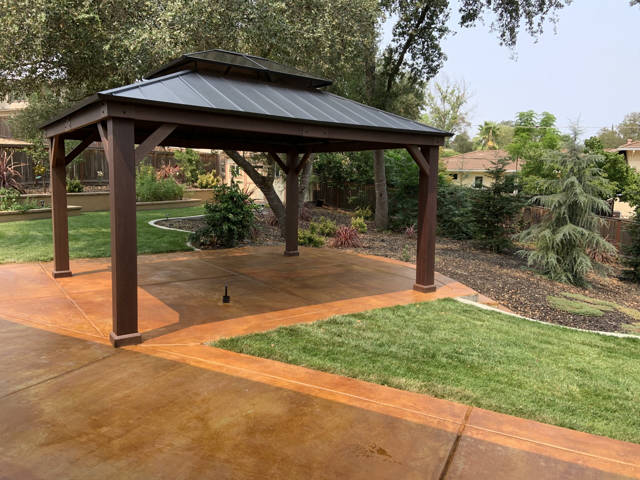 Outdoor kitchen featuring a gazebo, with the concrete enhanced by the warm hues of Cola stain