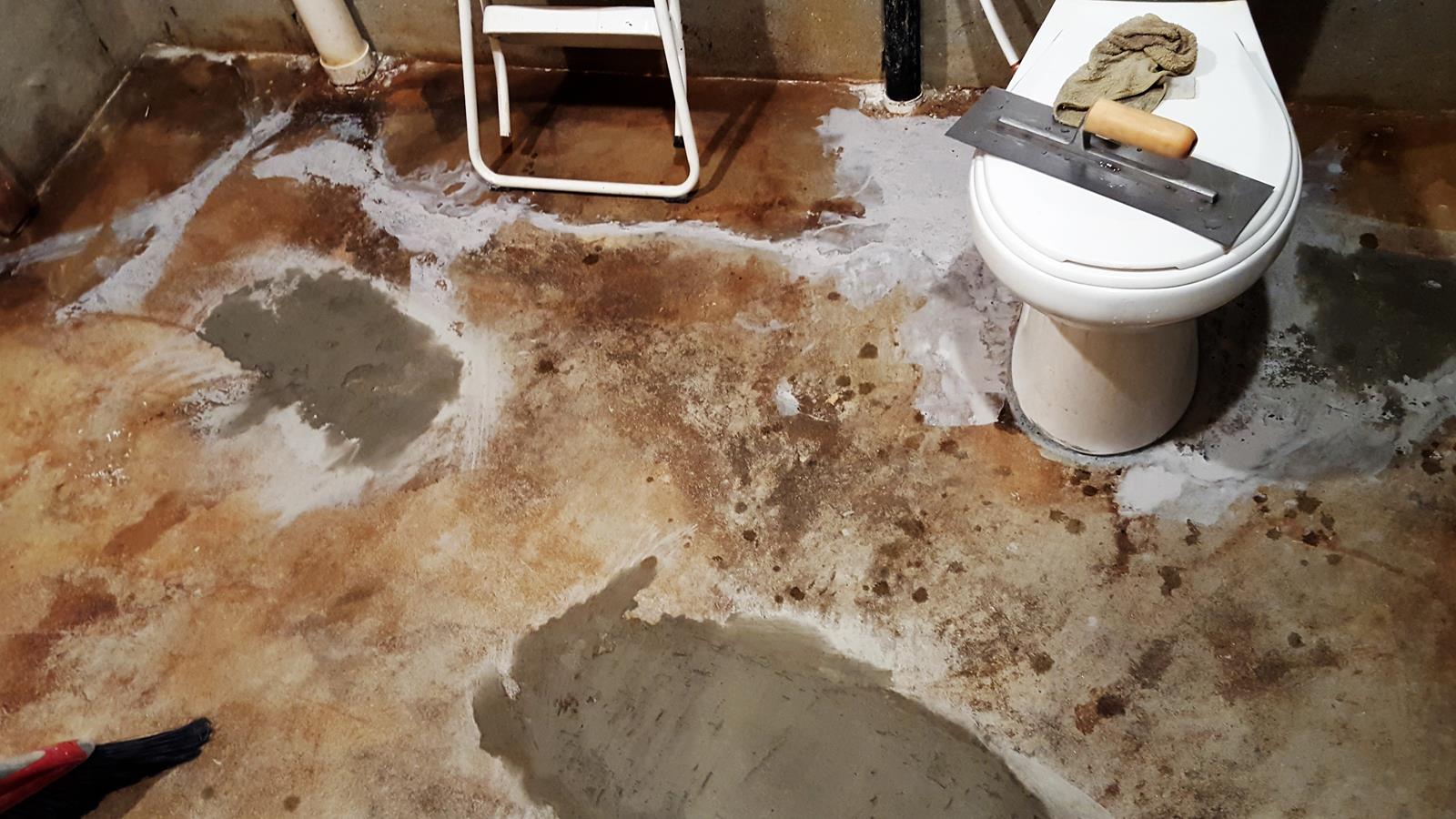 cracks in the bathroom's concrete floor are repaired with a gray concrete overlay