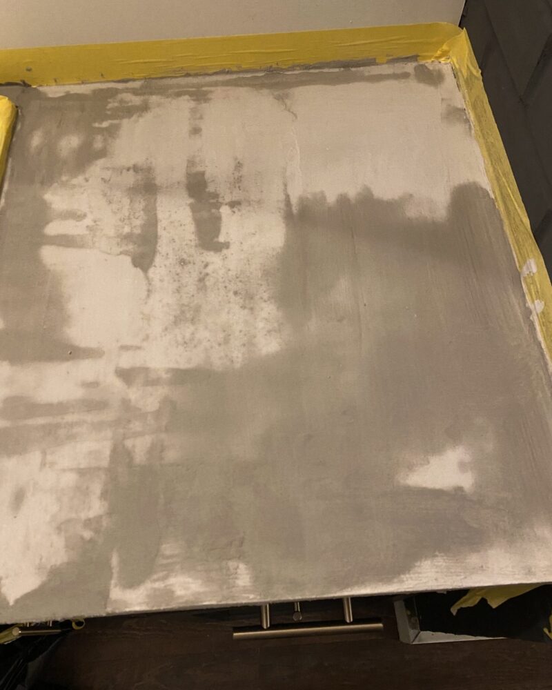 Ash gray smooth concrete overlay over laminate bathroom vanity countertop