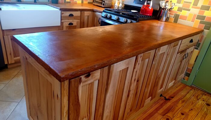 Stunning Cola and Malayan Buff Everstain acid stained finish enhances Beachfront Buff pigmented concrete overlay kitchen countertop.