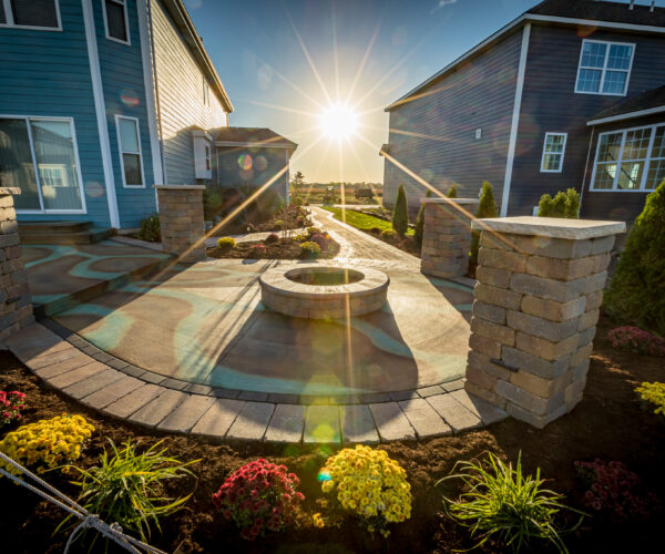 Round patio with fire pit stained in black, malayan buff, and seagrass using wet-on-dry acid staining technique