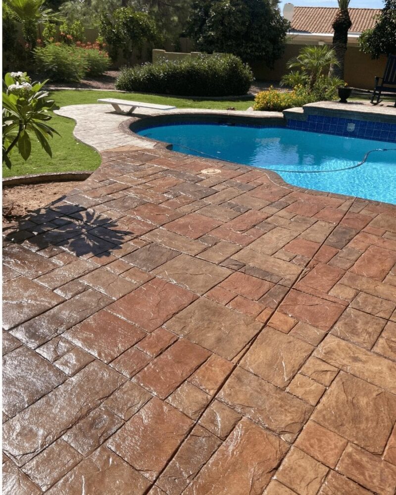 Revived stamped concrete pool deck with Antiquing Cumin, Driftwood, and Terracotta Concrete Stain Colors