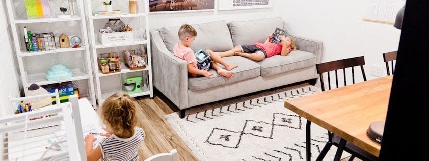 Three children play and work in their homemade DIY homeschool classroom