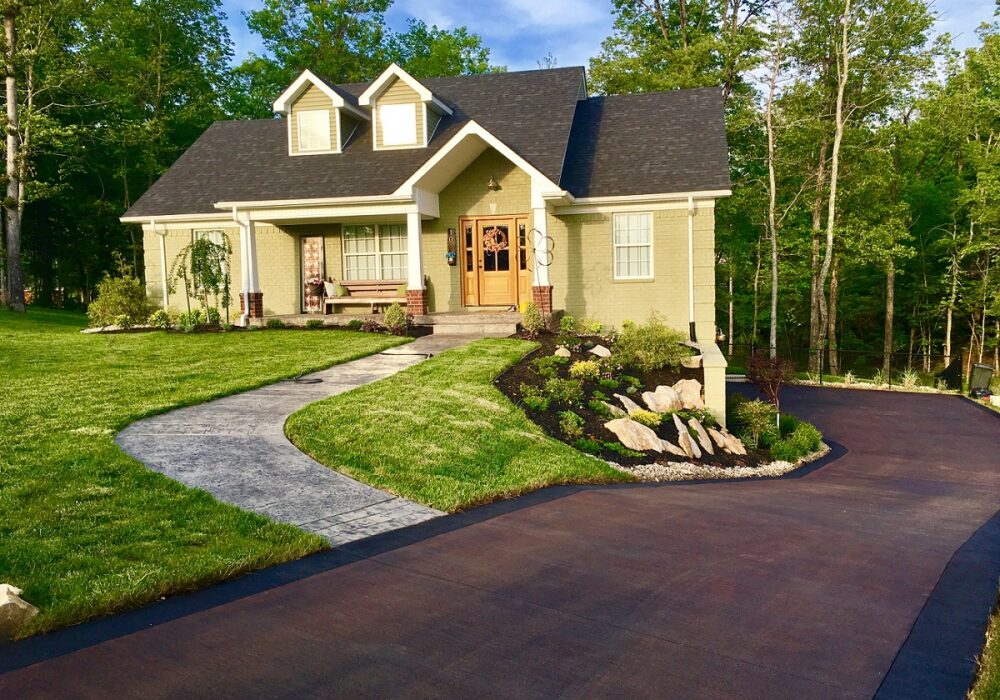 Long side driveway stained with coffee brown acid stain and edged with charcoal EasyTint for added detail.
