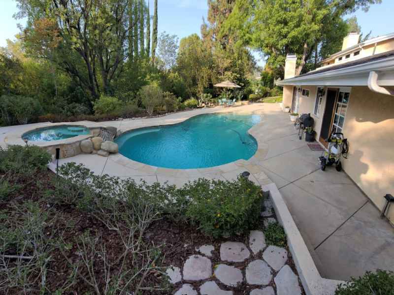 A large, faded stamped concrete space before the staining and sealing process.