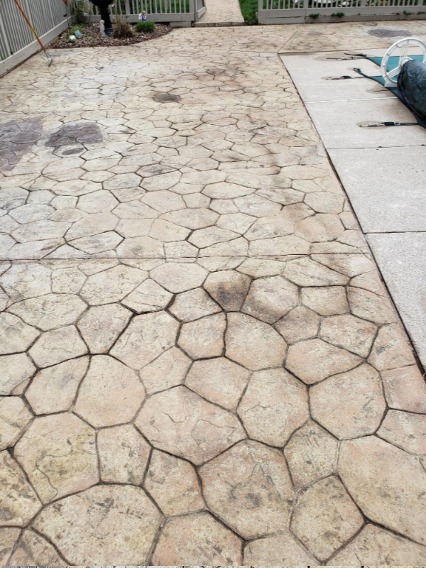Old stained stamped concrete pool deck in need of a color refresh