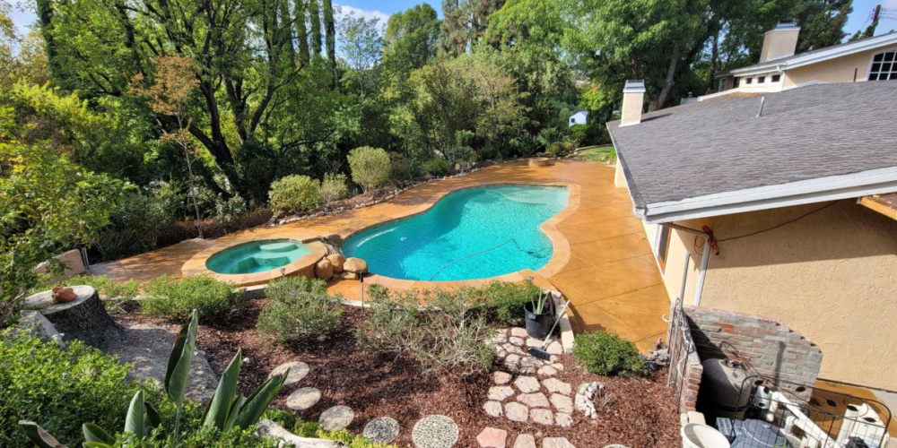 The same concrete space transformed into a vibrant backyard haven after staining with Yukon Gold Antiquing Stain and sealing with Solvent Based Acrylic Satin Concrete Sealer