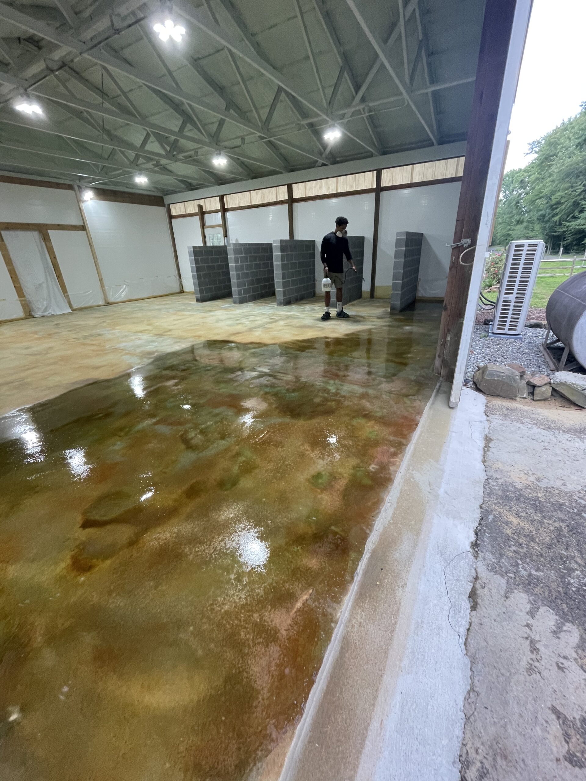A person carefully applying EasySeal solvent-sealer on the floor, equipped with a mask to protect against fumes - Avocado-Malayan-EverStain