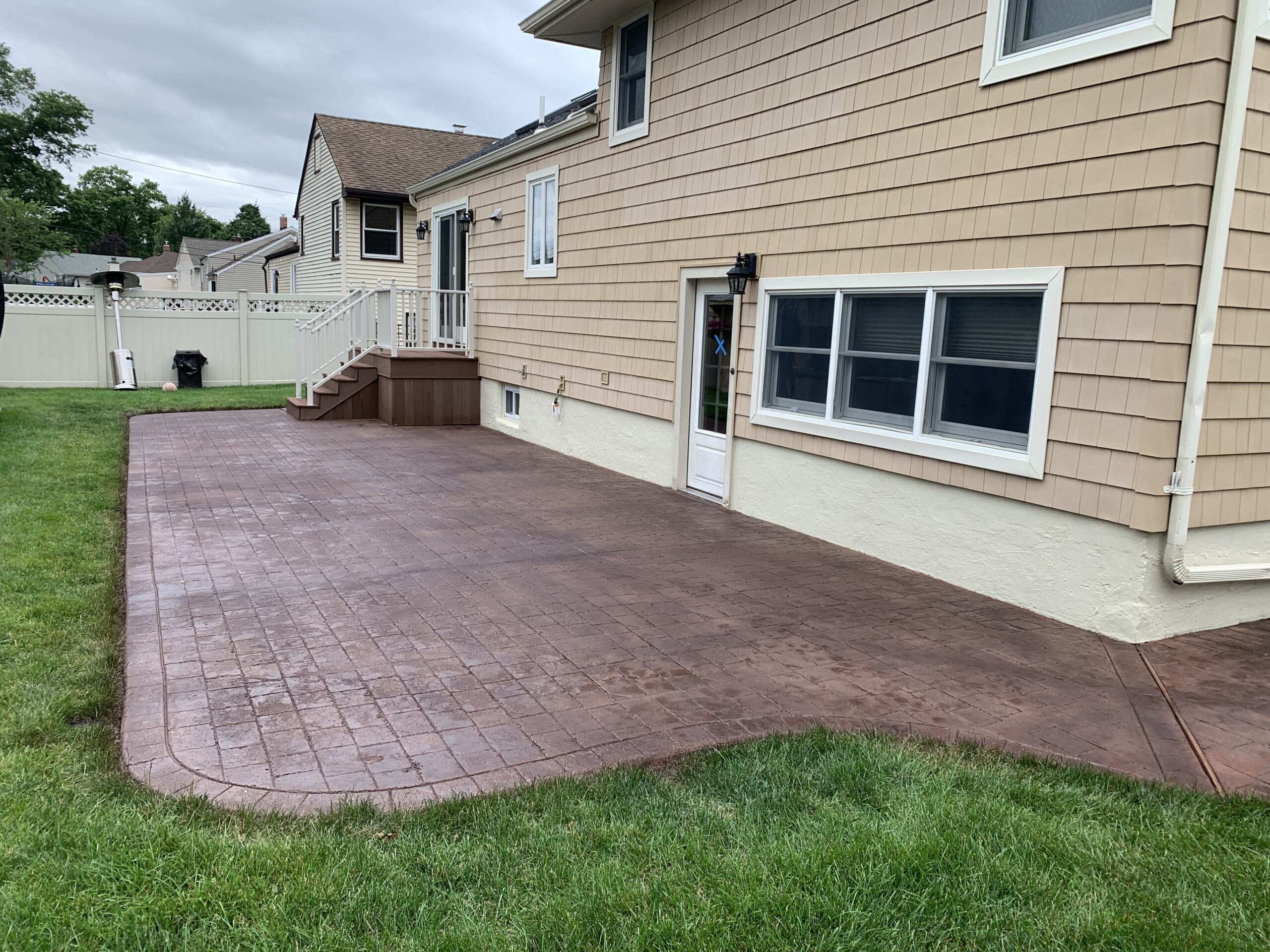 cracked stamped concrete patio repaired using concrete patching compound and recolored with Aztec Brown Antiquing stain