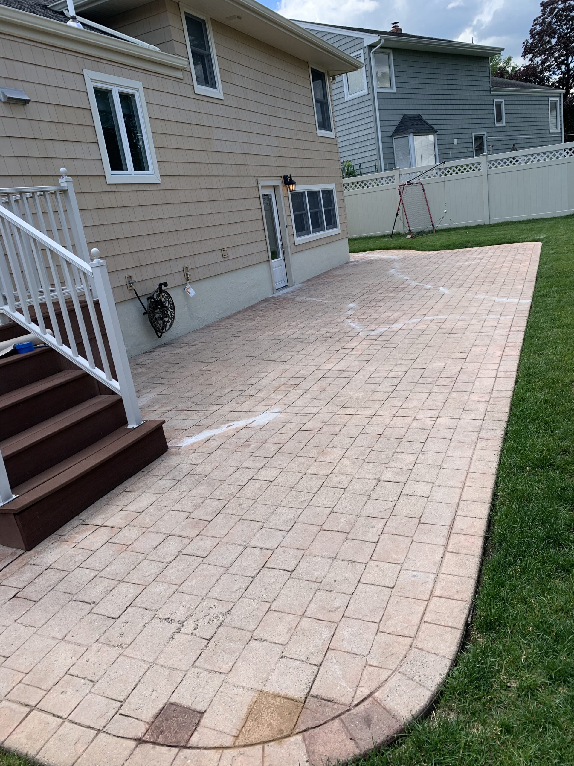 Photo of a cracked and faded stamped concrete patio