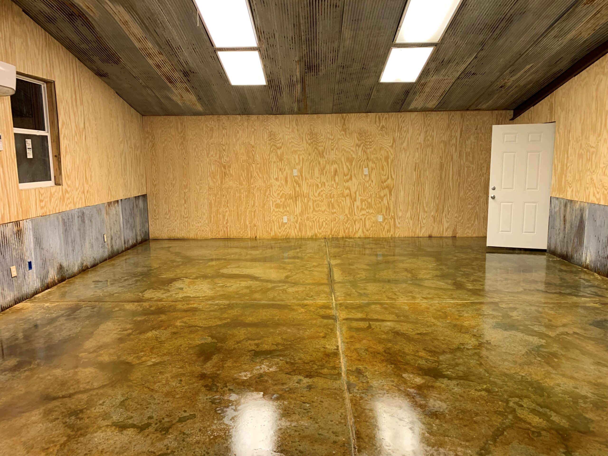 A final shot of a sealed concrete floor, revealing the Avocado and Malayan Bluff stain's enhanced colors after the application of a high-gloss sealer.