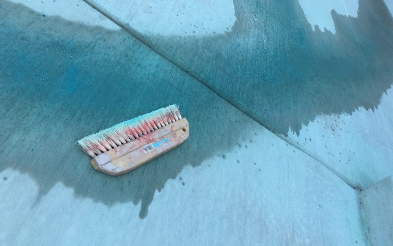 use a brush to spread acid stain and Miracle Gro mixture