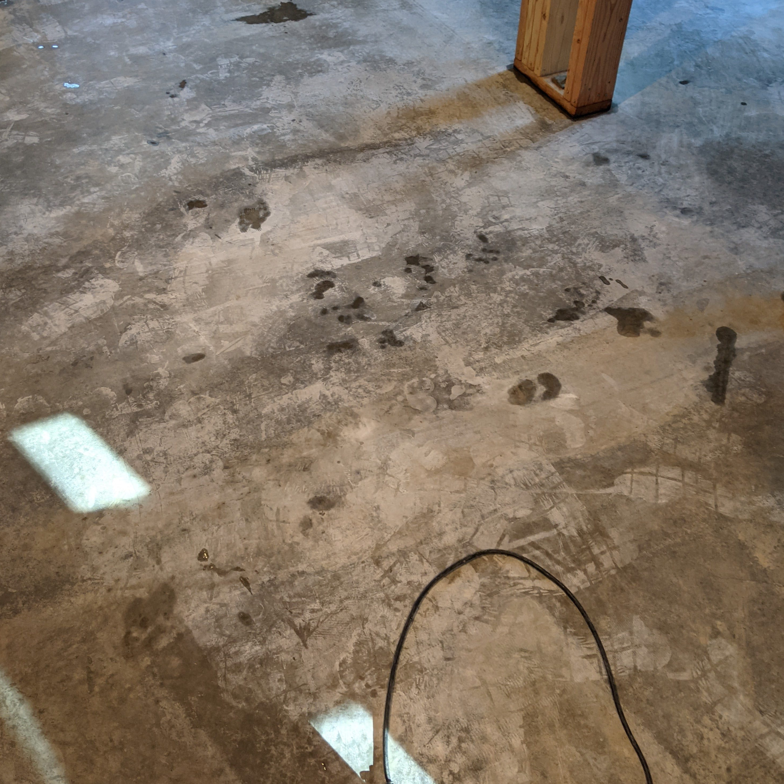 Footprints etched into concrete floor due to tracked dust before staining