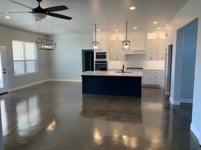 Concrete kitchen floor showcasing a modern mix of Stormy Gray, Driftwood, and Charcoal Vibrance Dye.