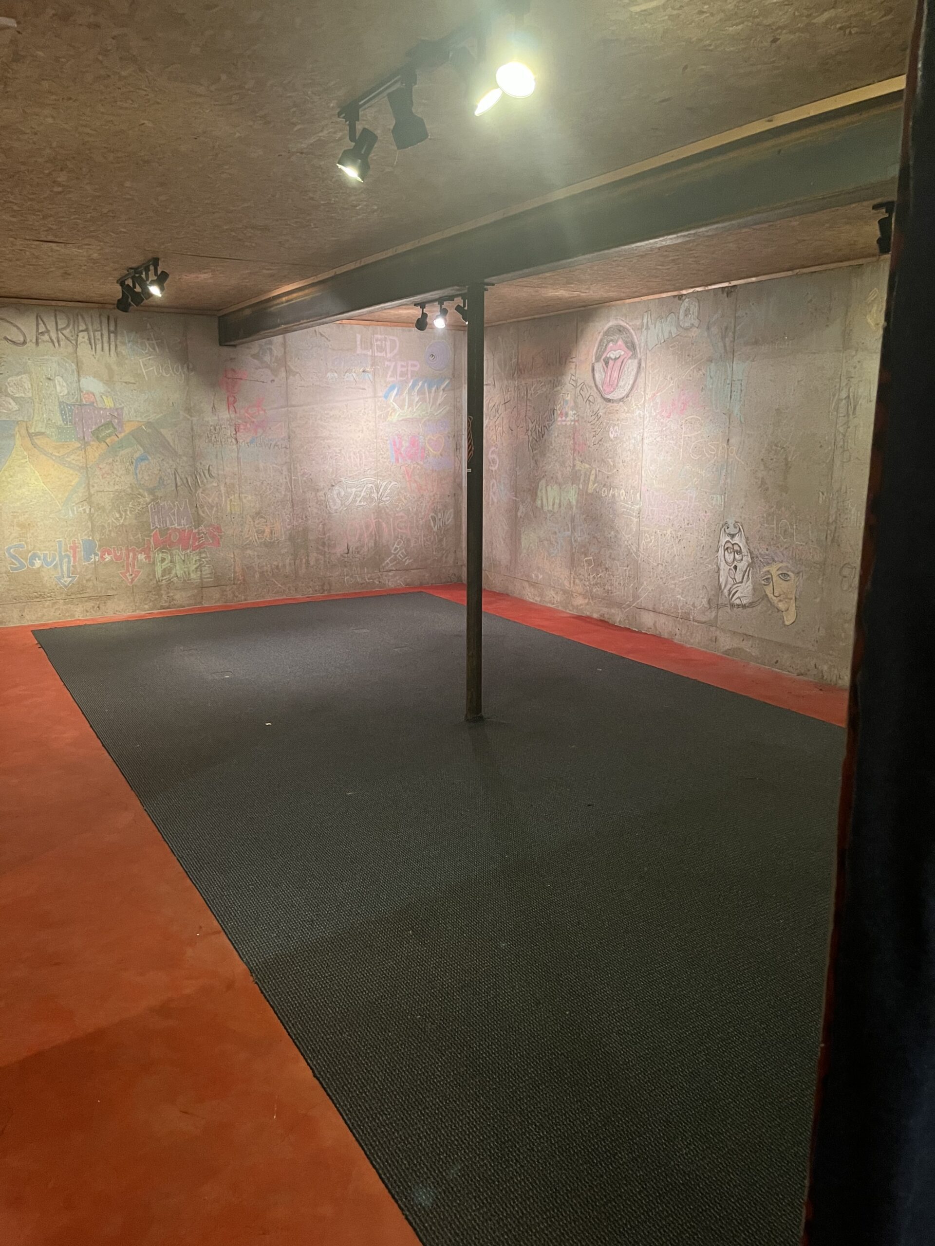 Bright red, neglected basement floor before refinishing