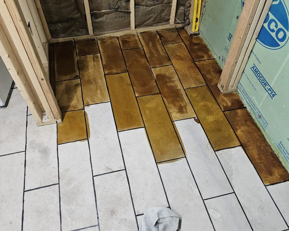 Applying Coffee Brown EverStain™ to the taped-off concrete floor