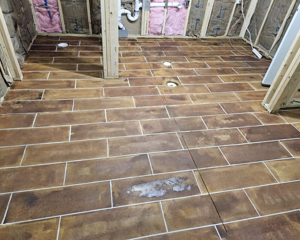 Revealing clean, crisp lines after removing the tape from the stained concrete floor