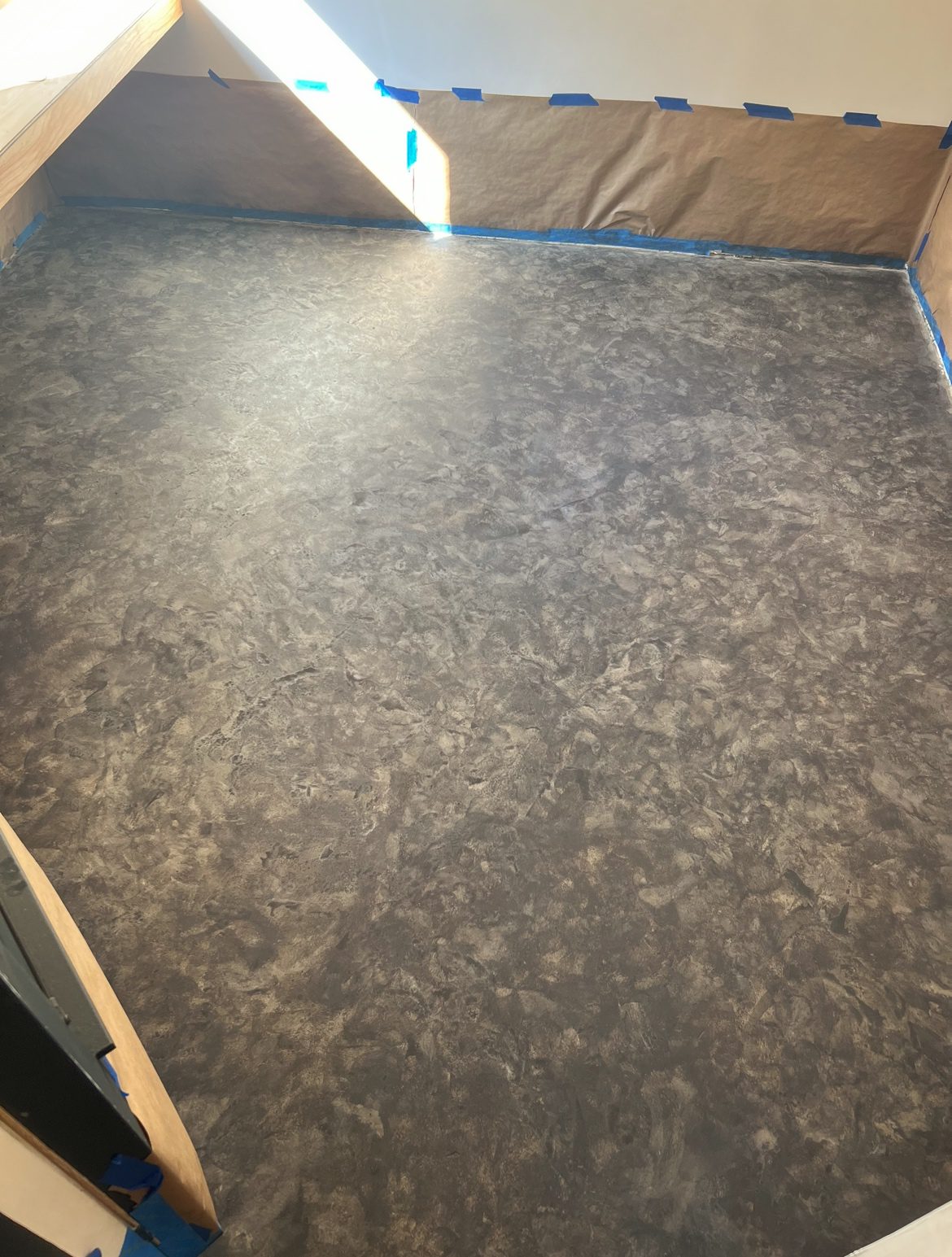 Concrete floor showing the depth and variation in color after a second coat of Charcoal Vibrance Dye applied with a sponge