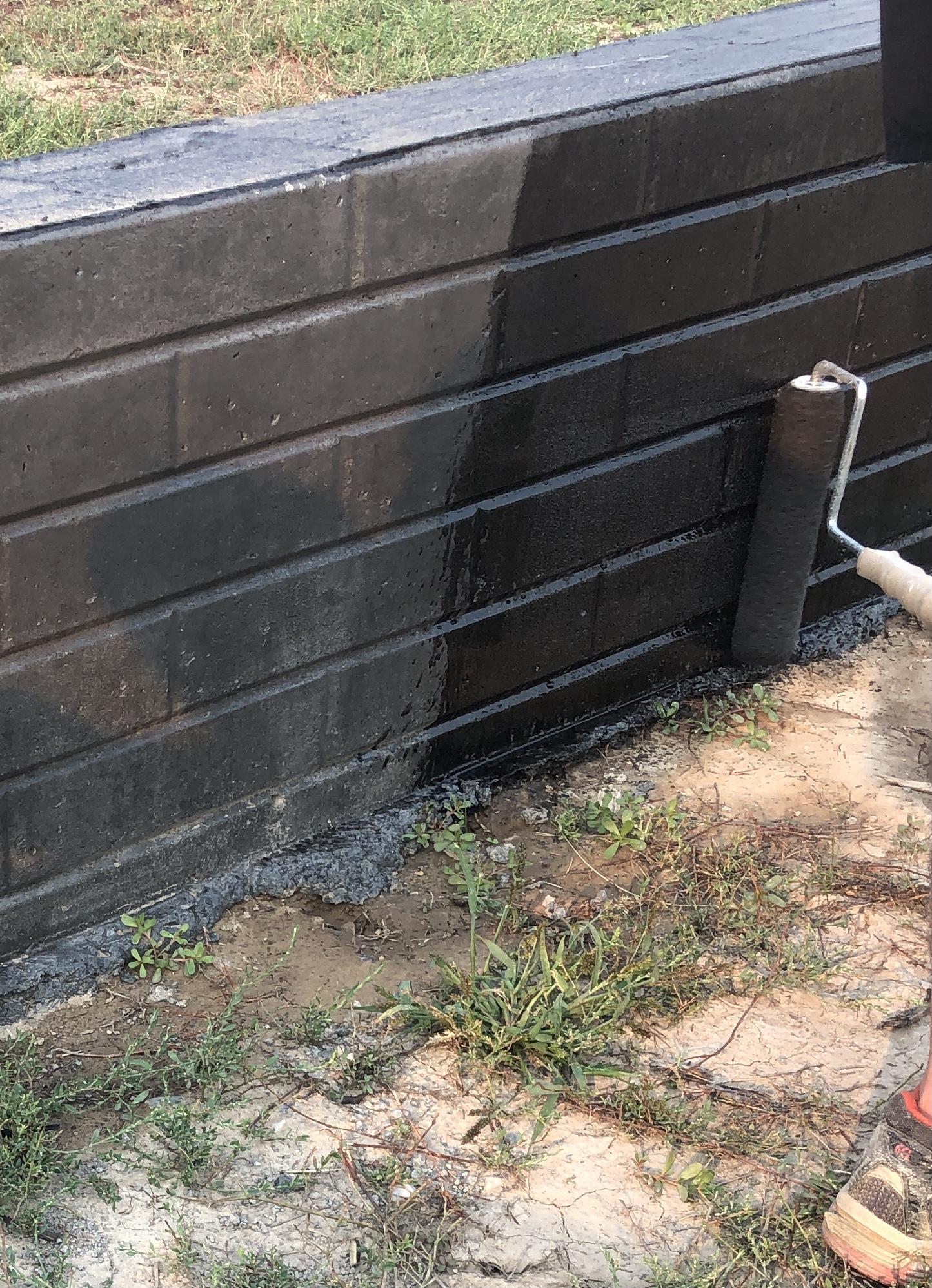 Stamped retaining wall being stained with a roller using Black EasyTint satin