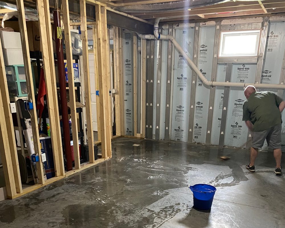 Man neutralizing and rinsing CitrusEtch solution from a concrete floor with a mop