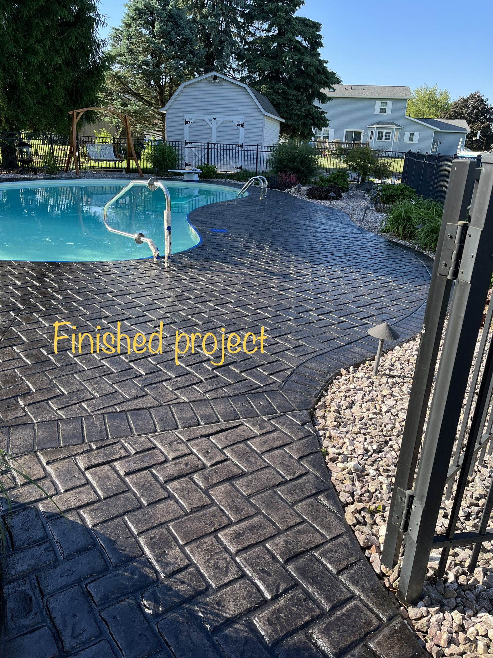 Revitalized concrete pool area after application of antiquing stain and sealer