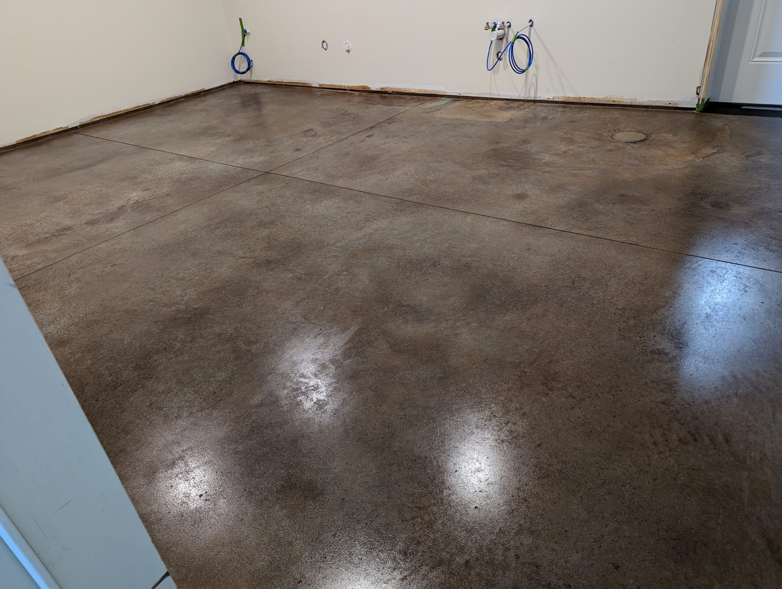 Garage floor showcasing the mixed Black and Malayan Buff acid stain colors, which were combined to create a unique and uniform shade for the garage floor instead of using multiple colors for patterns.