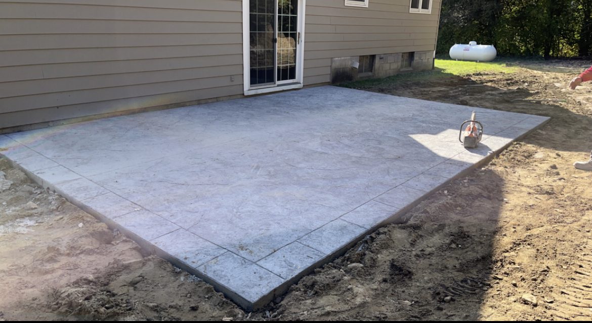 A black antiqued stamped concrete patio without border detailing or sealer