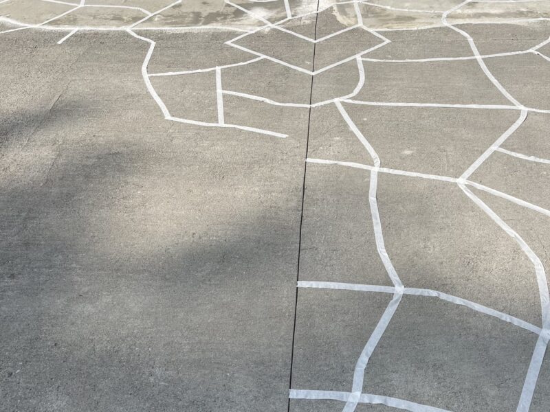 Patio floor marked with masking tape to outline faux flagstone design