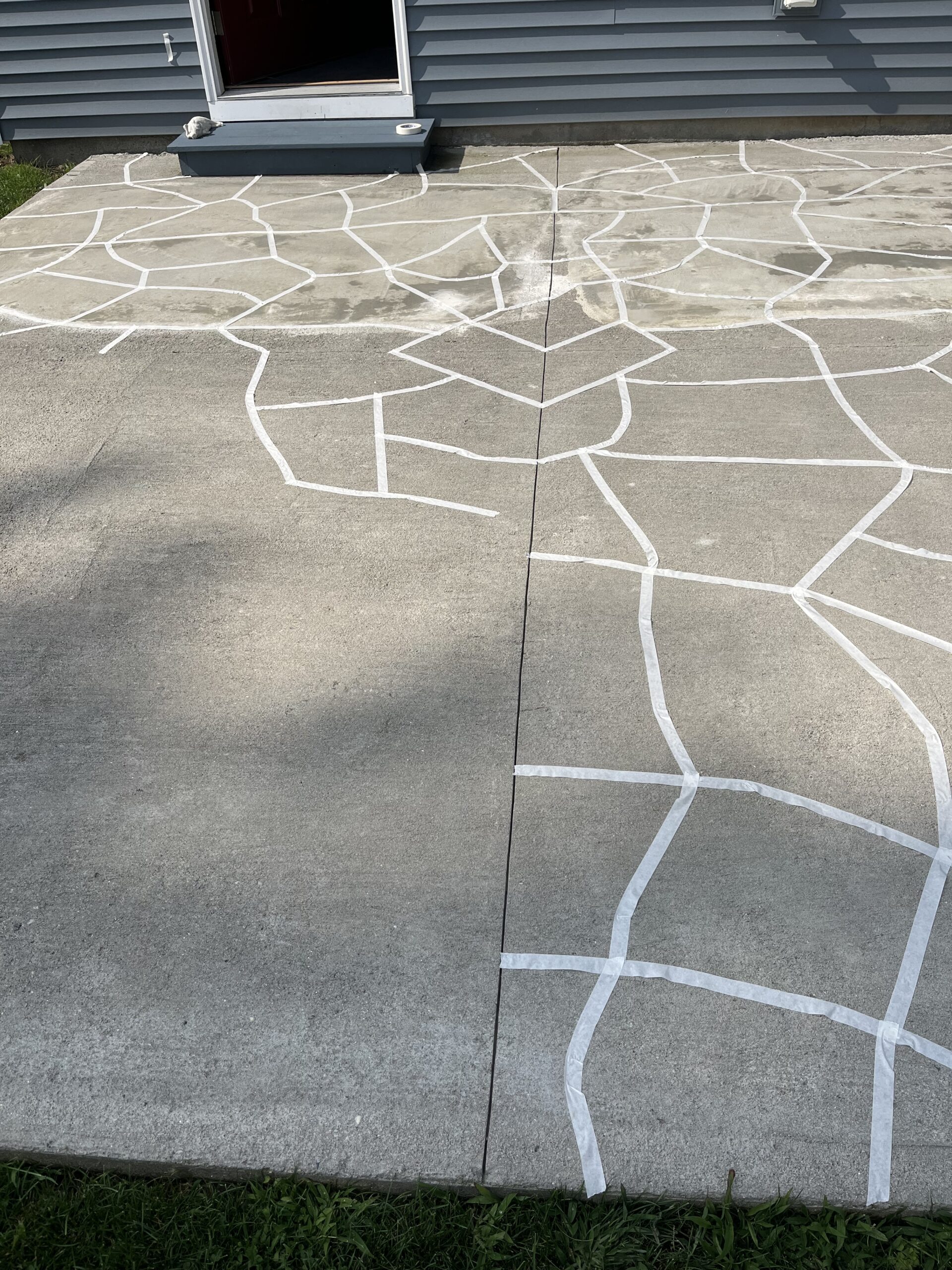 Patio floor marked with masking tape to outline faux flagstone design