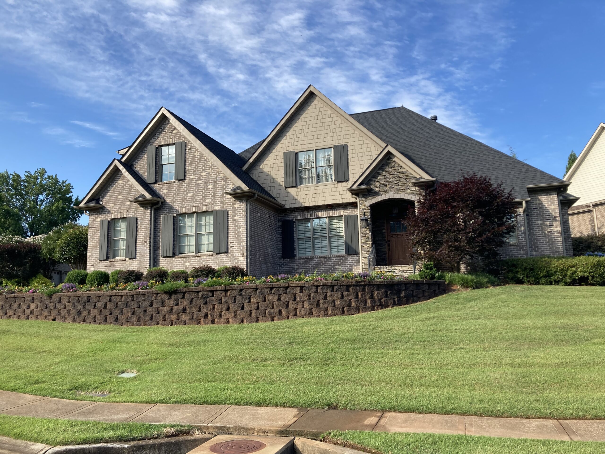 A rejuvenated retaining wall, uniformly stained in black, showcasing a fresh and cohesive appearance