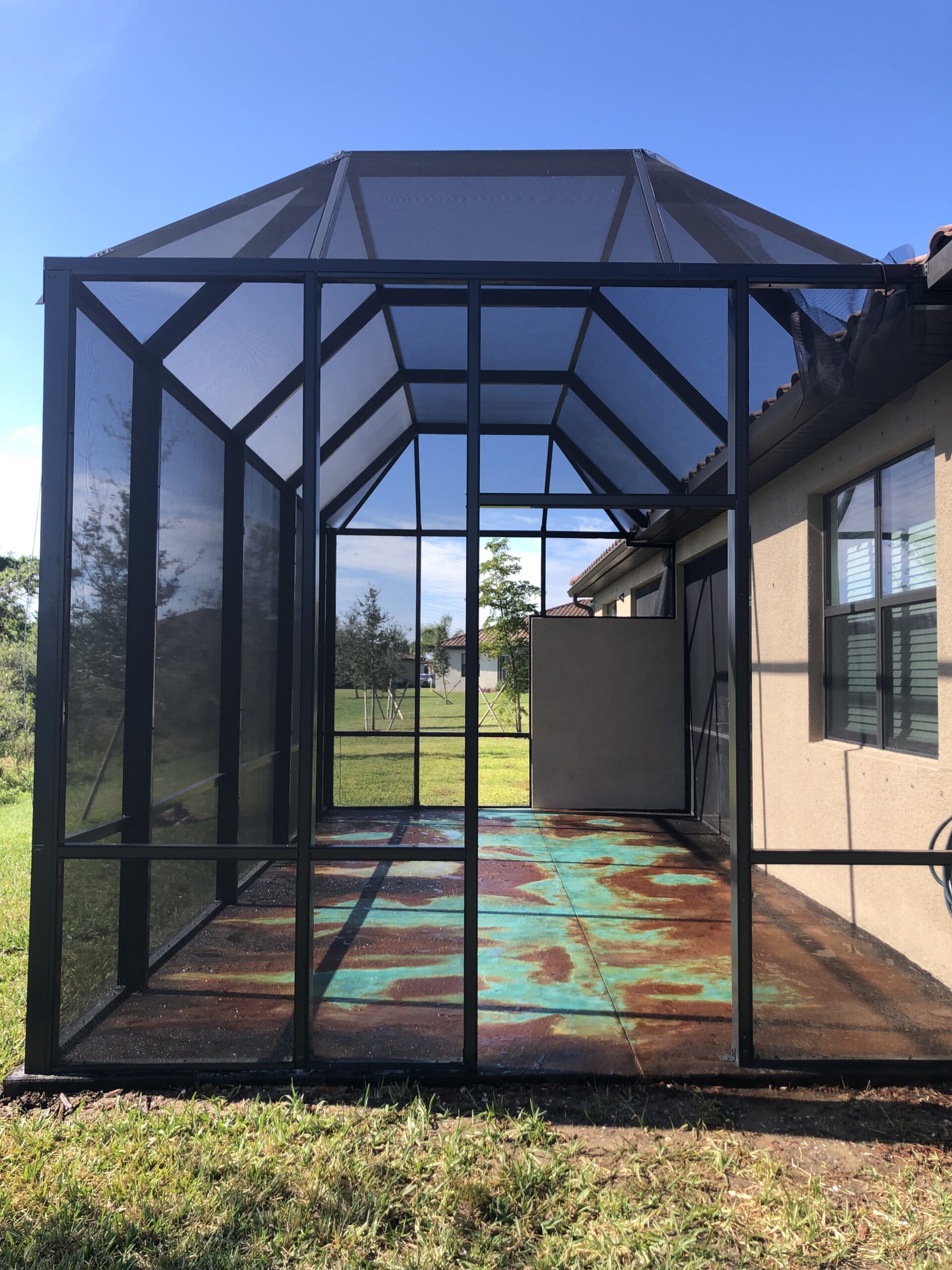 Beautiful concrete veining technique design on enclosed patio stained with black, english red and azure blue Everstain enhanced with Miracle Gro