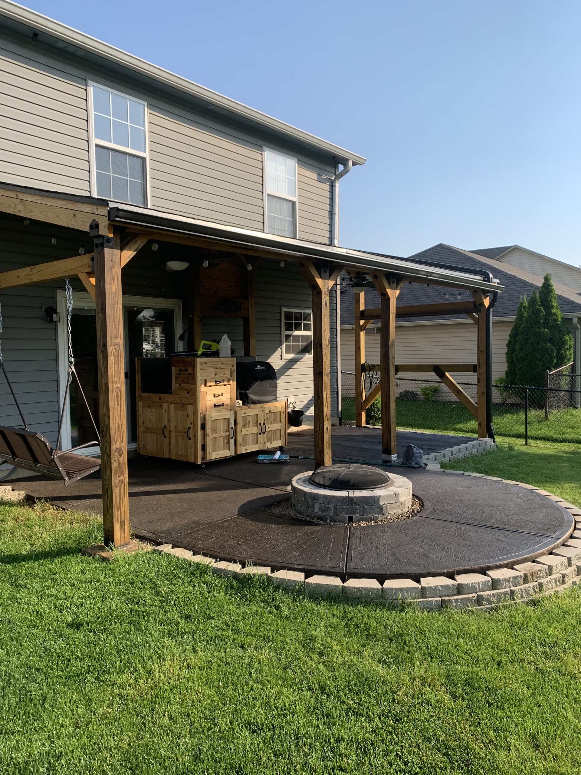 The patio, post-staining, with a harmonized blend of Coffee Brown and Black Everstain, diminishing the distinction between the old and new concrete
