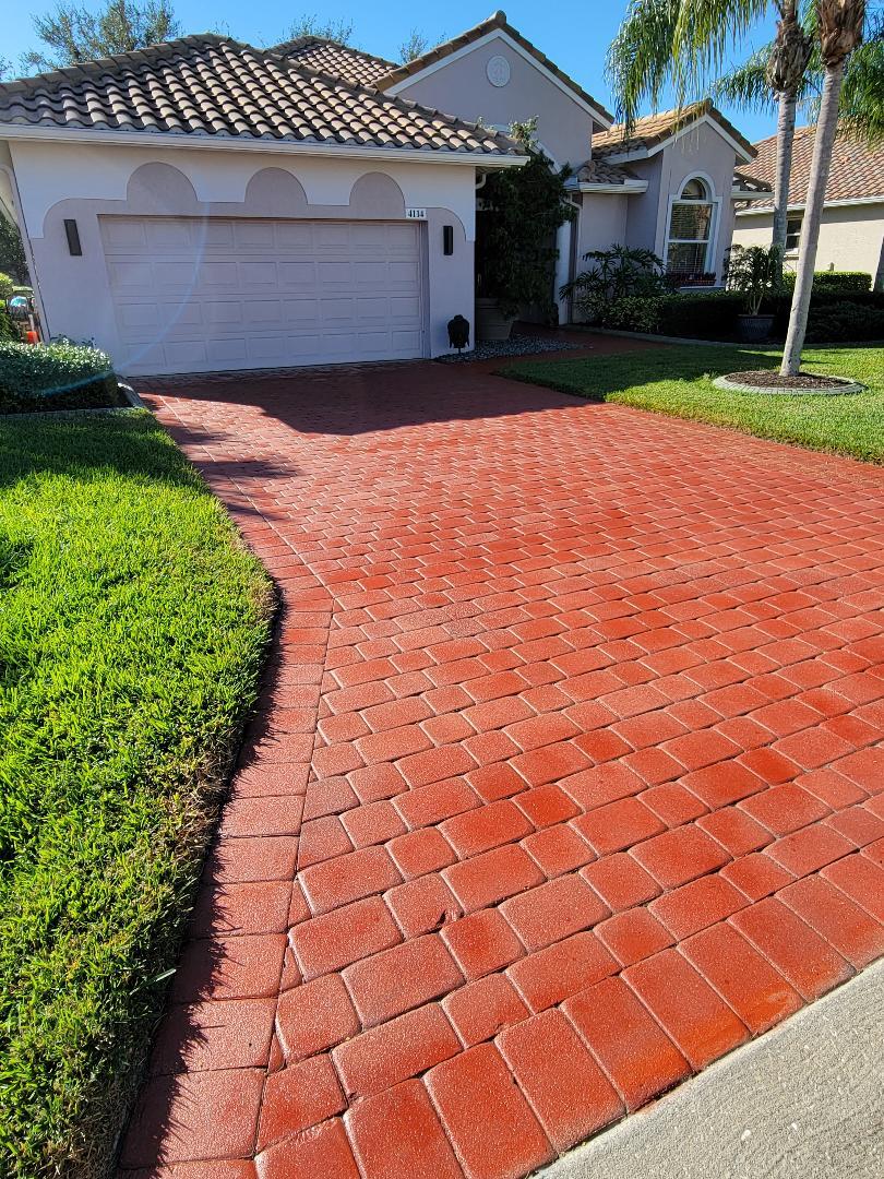 Crimson red stained concrete paver driveway with a smooth and glossy finish.