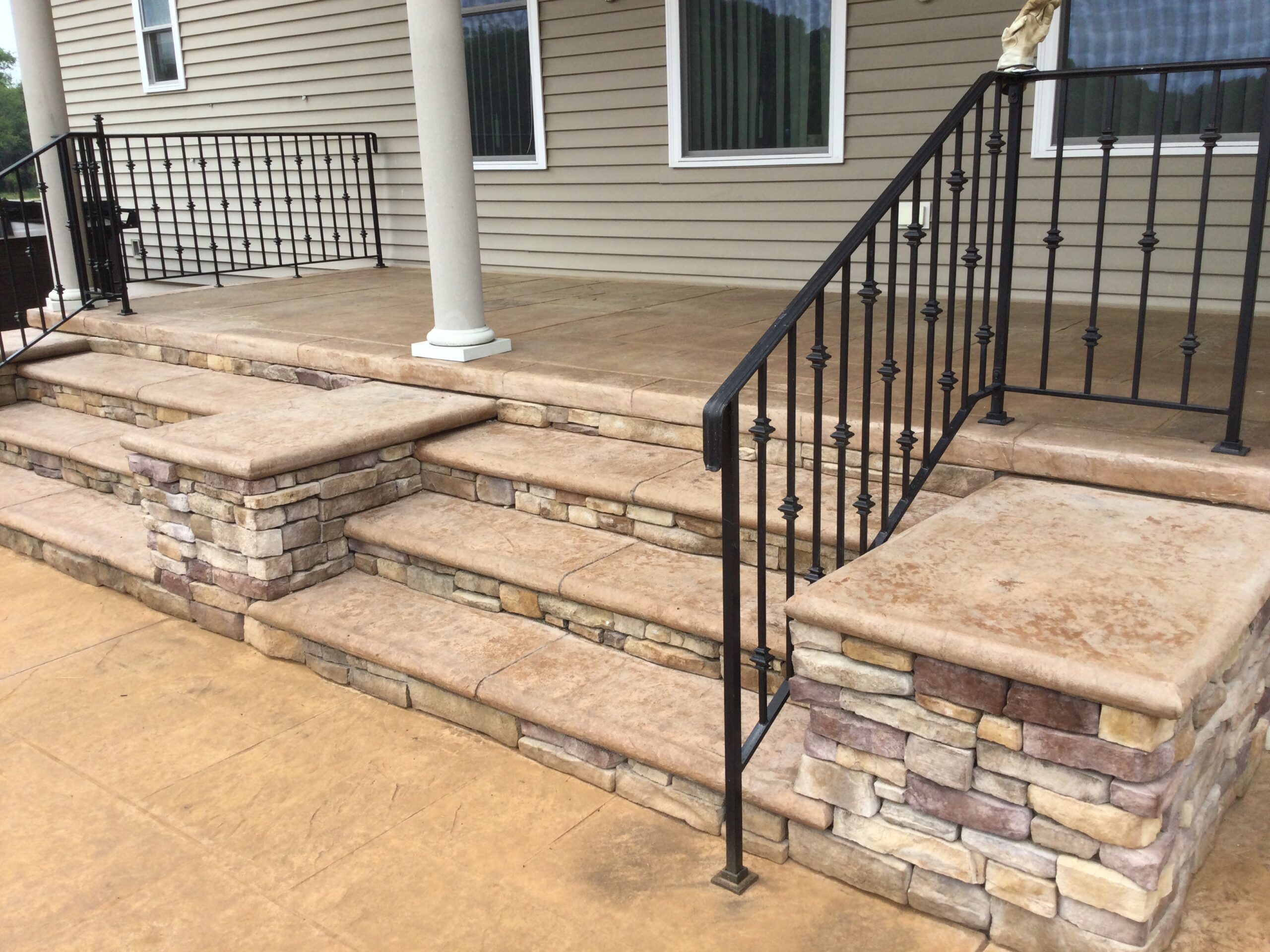 A sunlit back patio with faded, orangish stamped concrete before the application of Cafe Royale and Driftwood Antiquing™ Stains