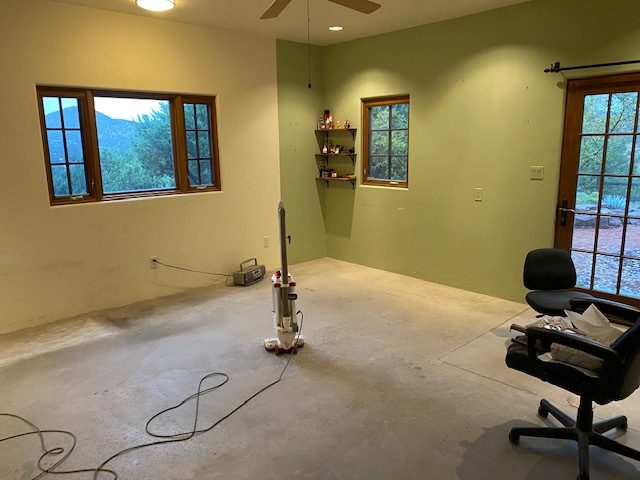 Photo showing a simple, bare concrete floor in a one-bedroom studio before staining