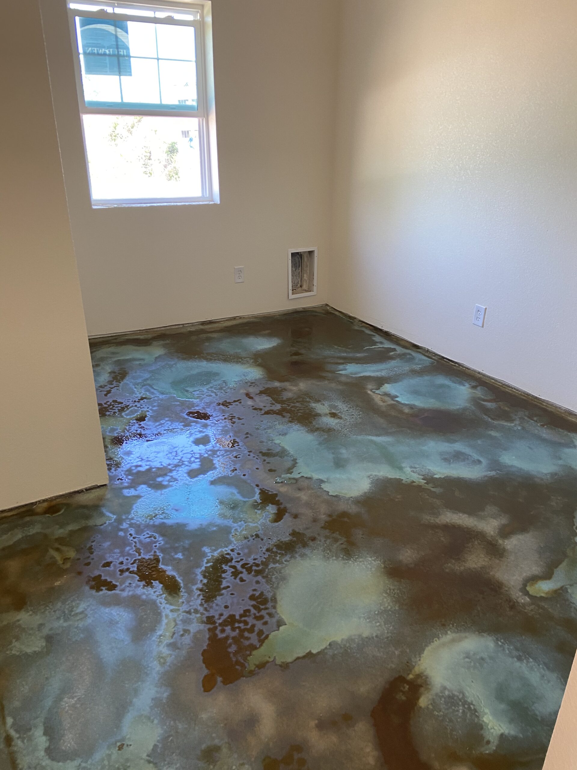 A photo showing Malayan Buff, Coffee Brown, and Seagrass acid stains applied on the bare concrete floor