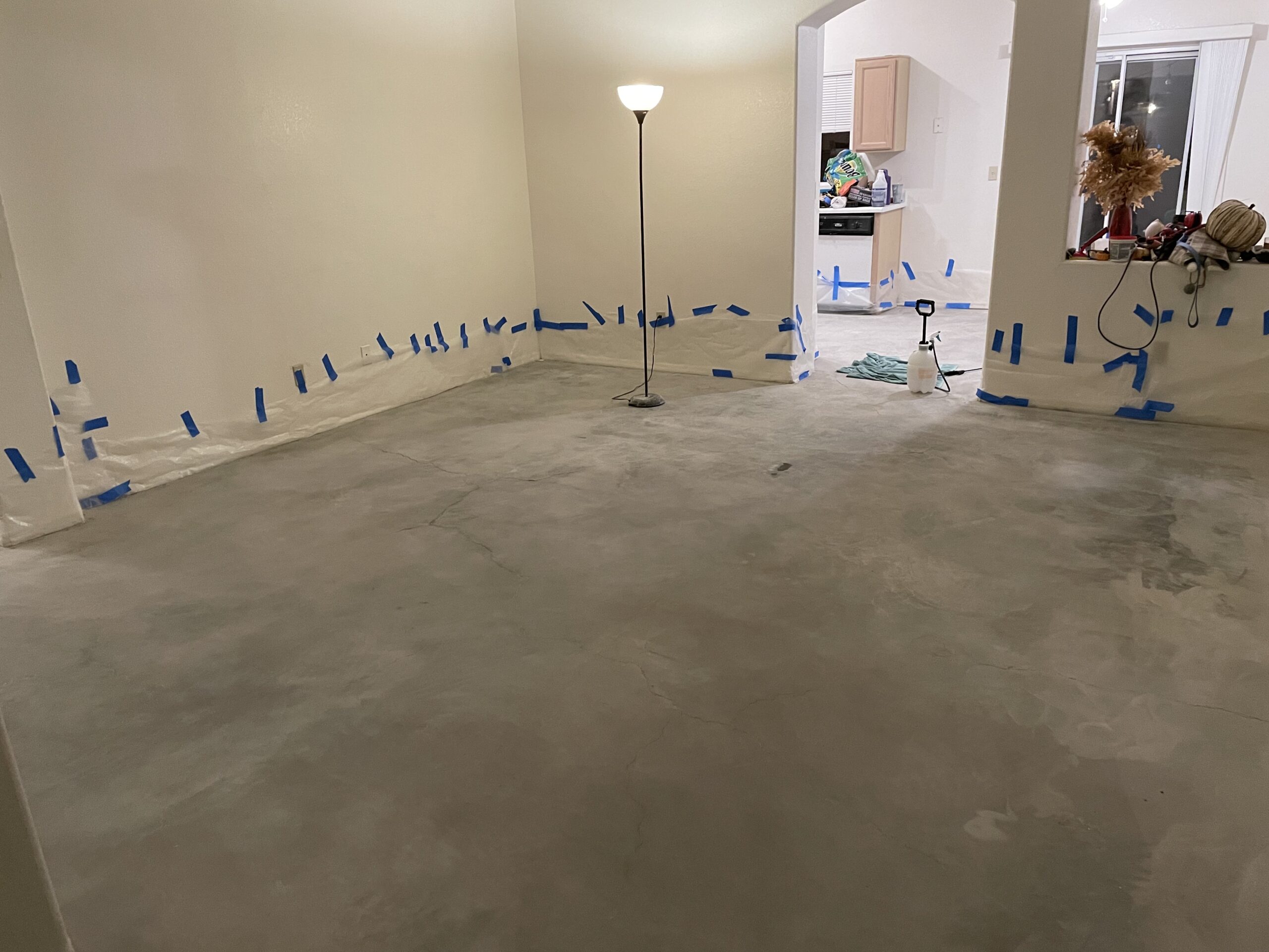 An image of a living room with bare, cleaned concrete floors, ready for the staining process.