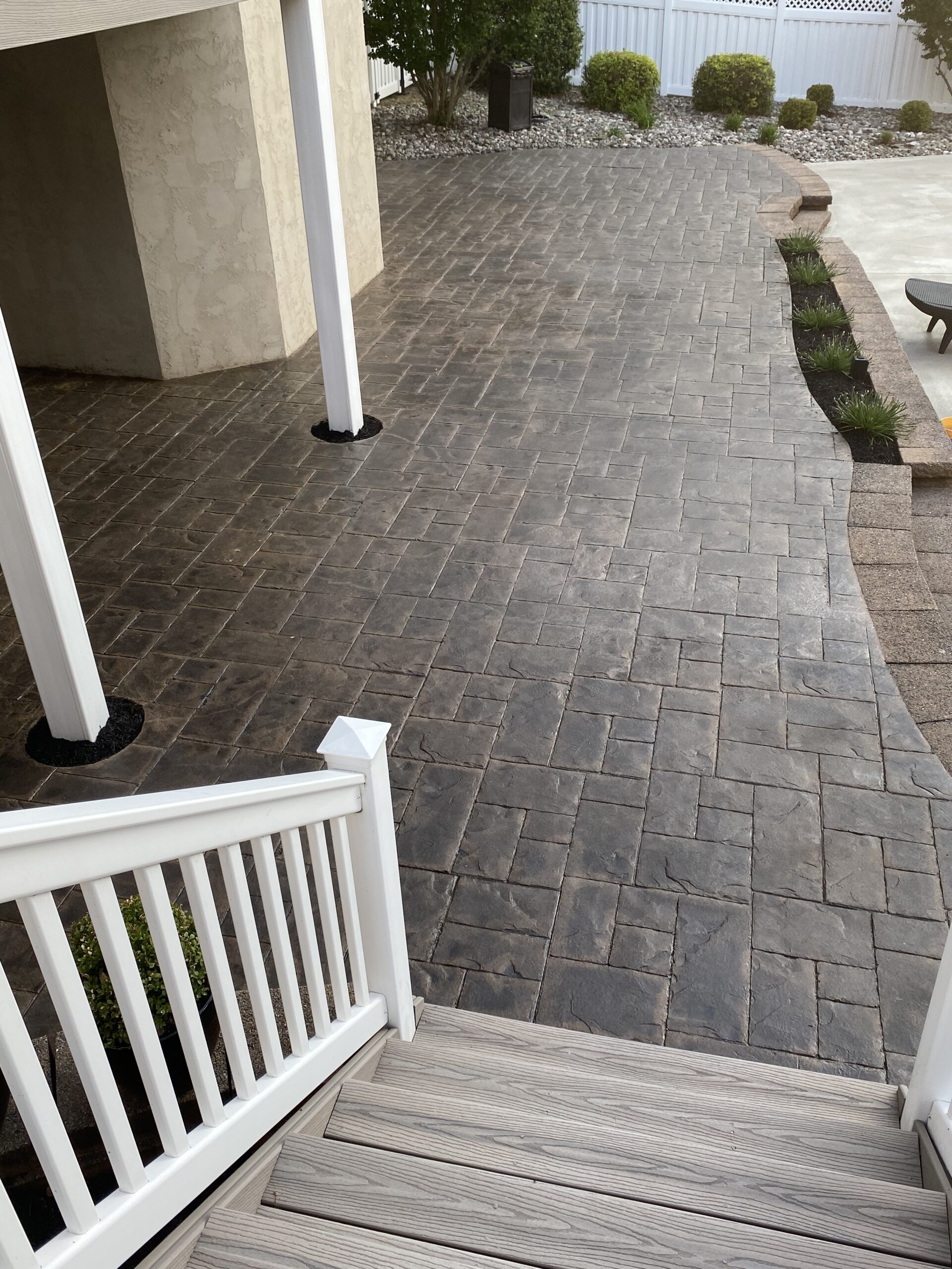 Multitoned charcoal stamped concrete floor with hints of brown undertones after application of stain