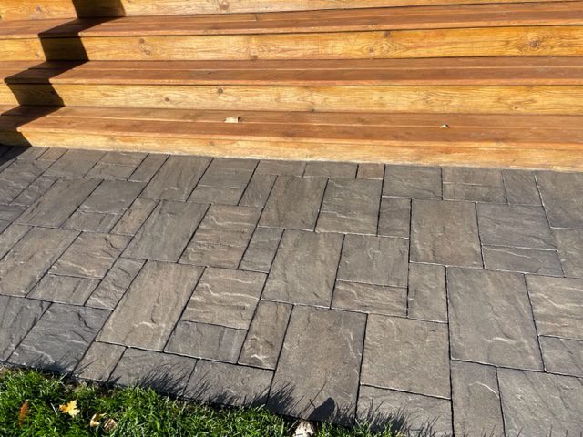 Stamped concrete deck transformed with a rich, charcoal hue achieved using EasyTint Tinted Sealer