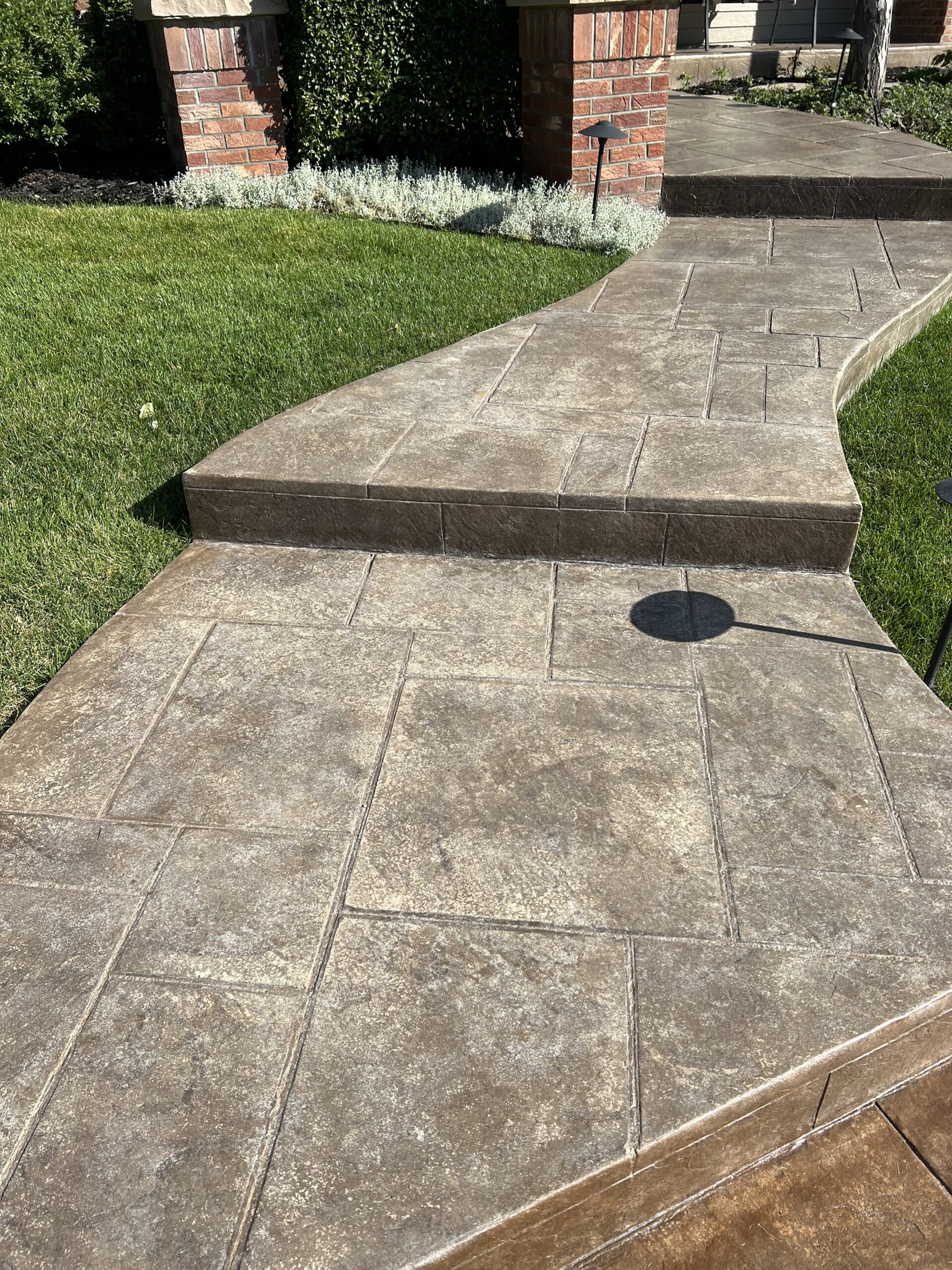 Faded stamped concrete walkway on a front porch