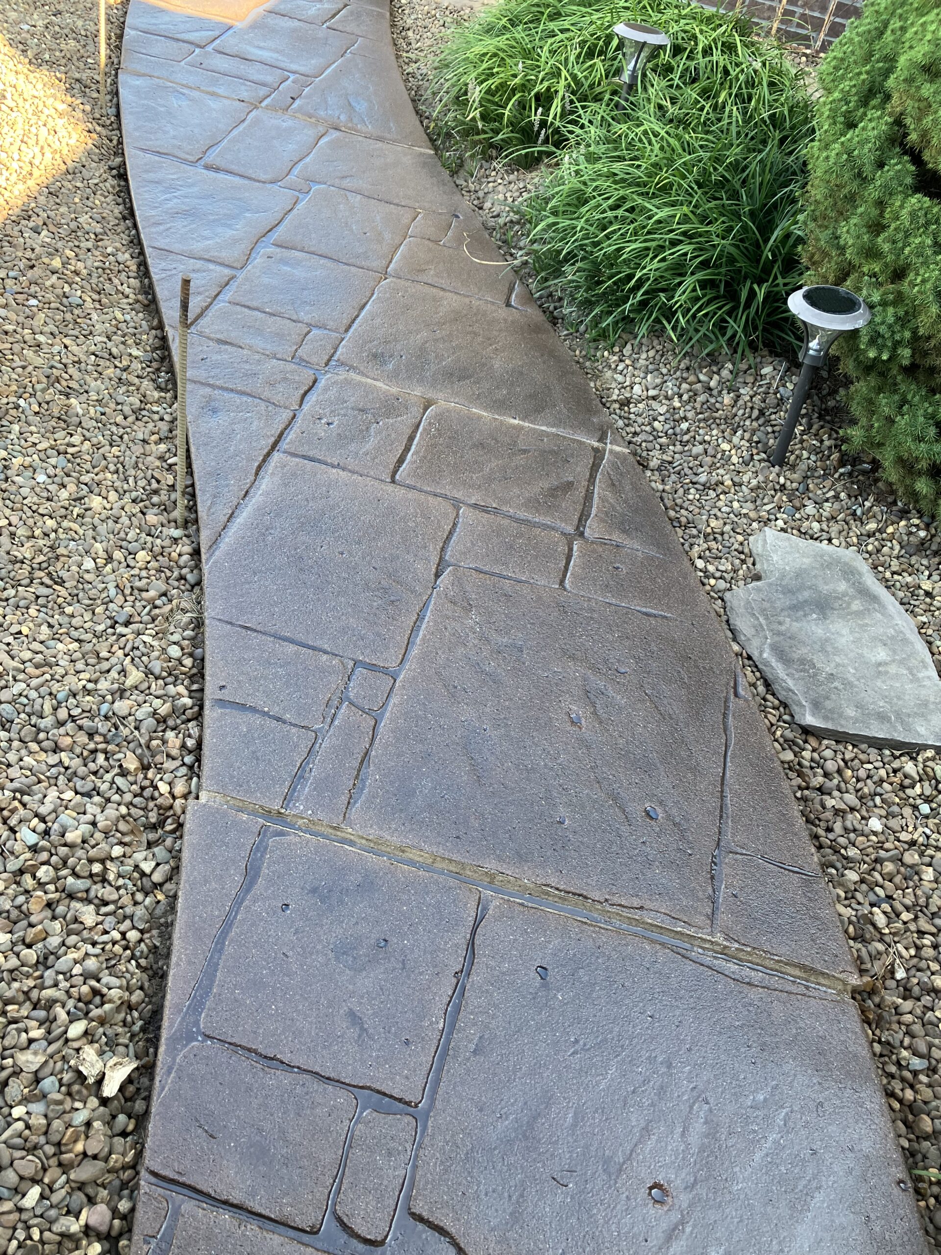 Revitalized stamped concrete sidewalk with Light Charcoal and Russet Antiquing™ stains