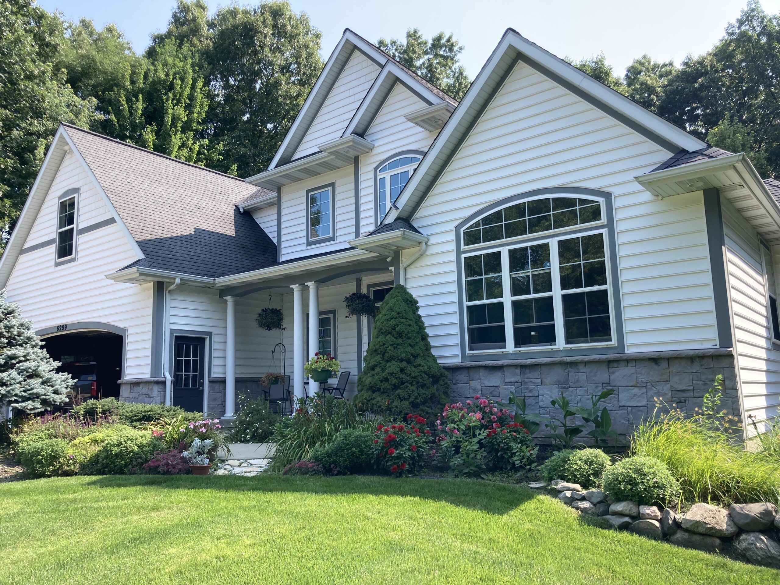 Full view of the house showcasing its original grey stone facade before staining