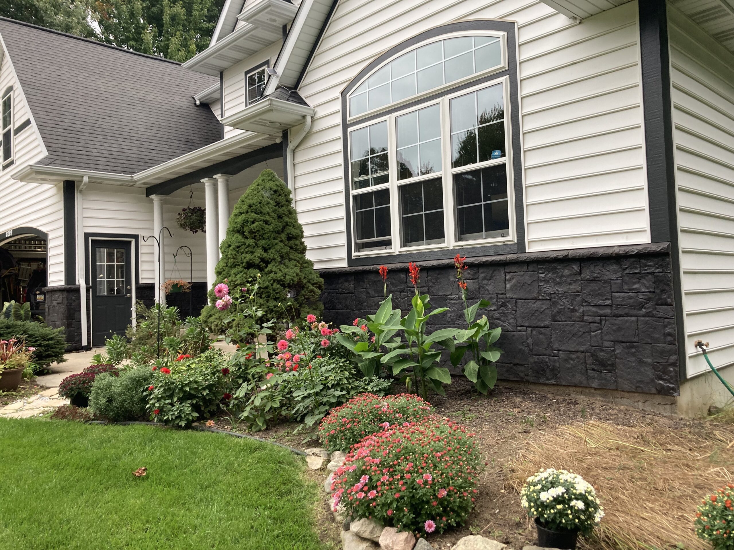 Full view of the house showcasing its finished Portico Black stone facade transformation
