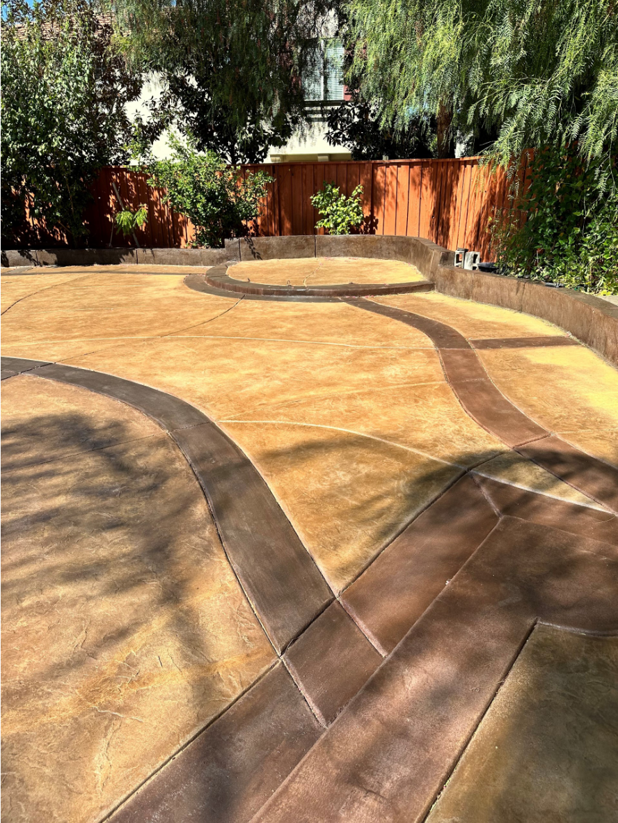 Backyard concrete patio refinished with Café Royale base color and Aztec Brown borders, creating a rich, uniform tone.