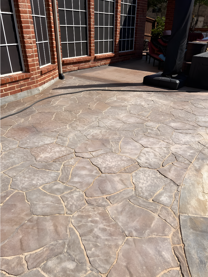 Stamped concrete patio with faded color and worn sealer before refinishing