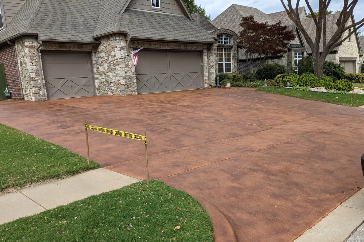 Large broom-finished concrete driveway stained in Aztec Brown and Terracotta showcasing a rich and even finish.