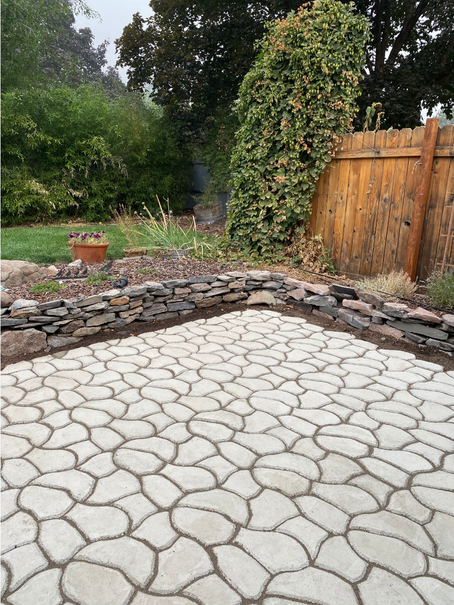 Stamped concrete patio before staining, showing a light gray surface
